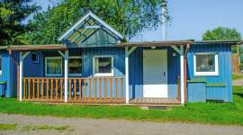 Blaues Holzferienhaus mit überdachter Terrasse im Geesthof Ferienpark