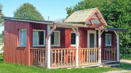 Rotes Holzferienhaus mit überdachter Veranda im Geesthof Ferienpark
