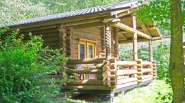 Blockhaus mit Holzveranda und gedrechselten Säulen im Geesthof Ferienpark