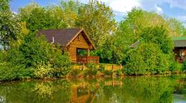Blockhütte am Wasser mit Veranda im Grünen