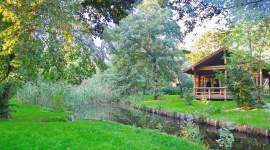 Blockhütte mit Veranda am Bach im Grünen