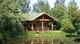 Blockhütte mit großer Veranda am Teich im Geesthof Ferienpark
