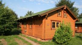 Blockhaus mit Giebelfenster und grünem Dach im Geesthof Ferienpark