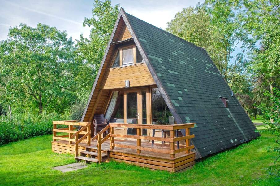 Foto von dem Nurdachhaus 379 auf einer Rasenfläche.