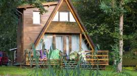 A-Ferienhaus mit Anbau und Holzterrasse am Teich