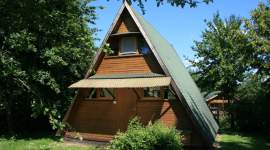 A-förmiges Ferienhaus mit grünem Dach und Vordach im Geesthof Ferienpark