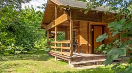 Blockhaus mit überdachter Holzveranda im Grünen