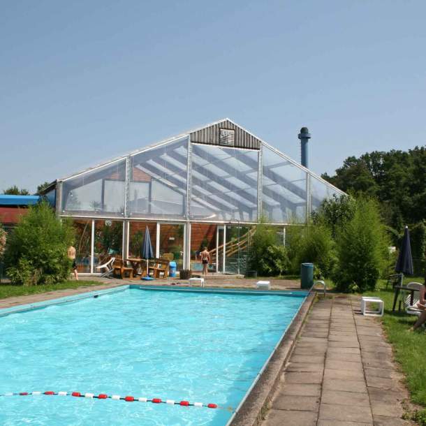 Foto eines Freibades mit Wiese zum Sonnen.