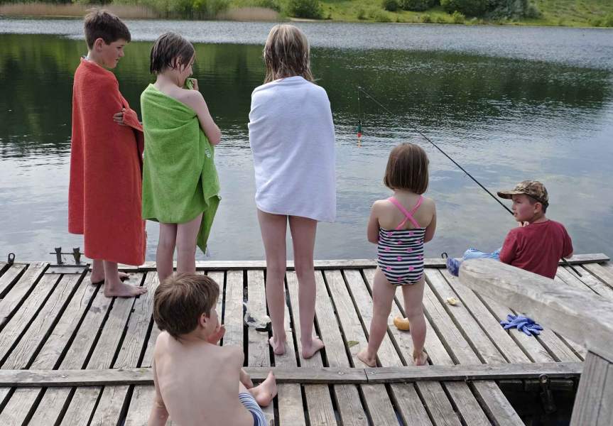 Foto von mehreren Kindern, die auf einem Steg am Geestsee stehen.