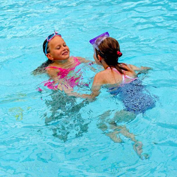 Foto von zwei Mädchen, die gemeinsam im Wasser baden.