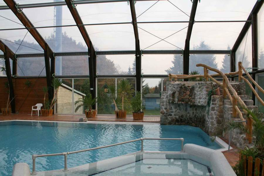 Foto des Schwimmbads "Badeparadies" mit Kinderbecken und kleinem Wasserfall.