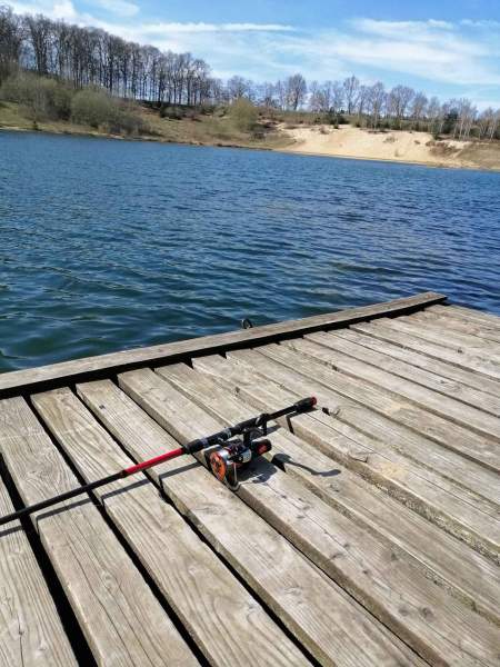 Foto einer Angel, die auf einem Steg am Geestsee liegt.