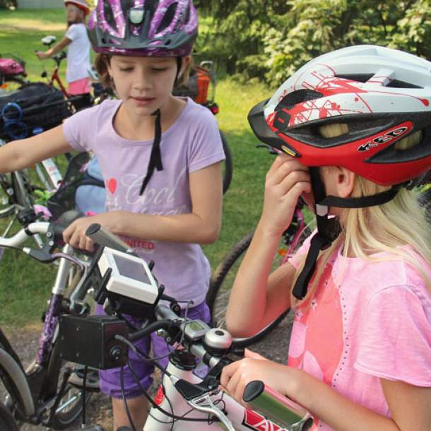 Foto von zwei Mädchen mit Fahrräder und bunten Fahrradhelmen.