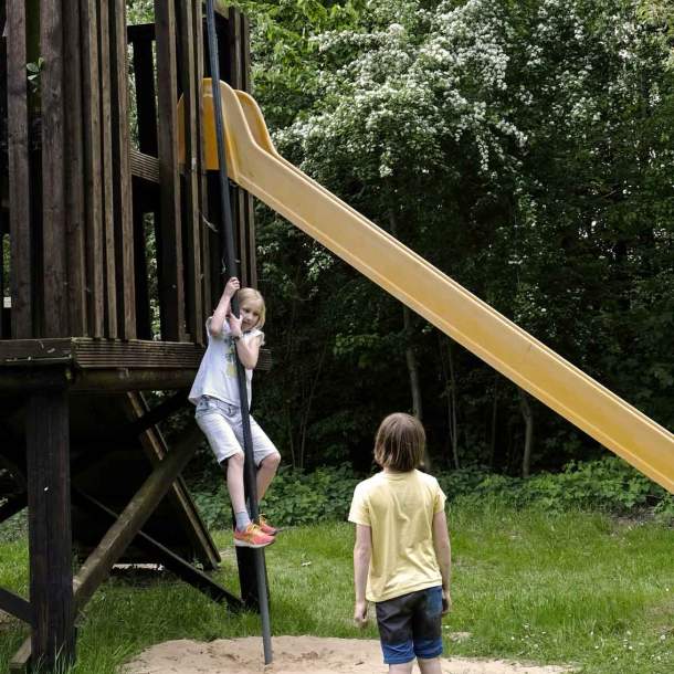 Foto von zwei Kindern auf einem Spielplatz mit Klettergerüst.