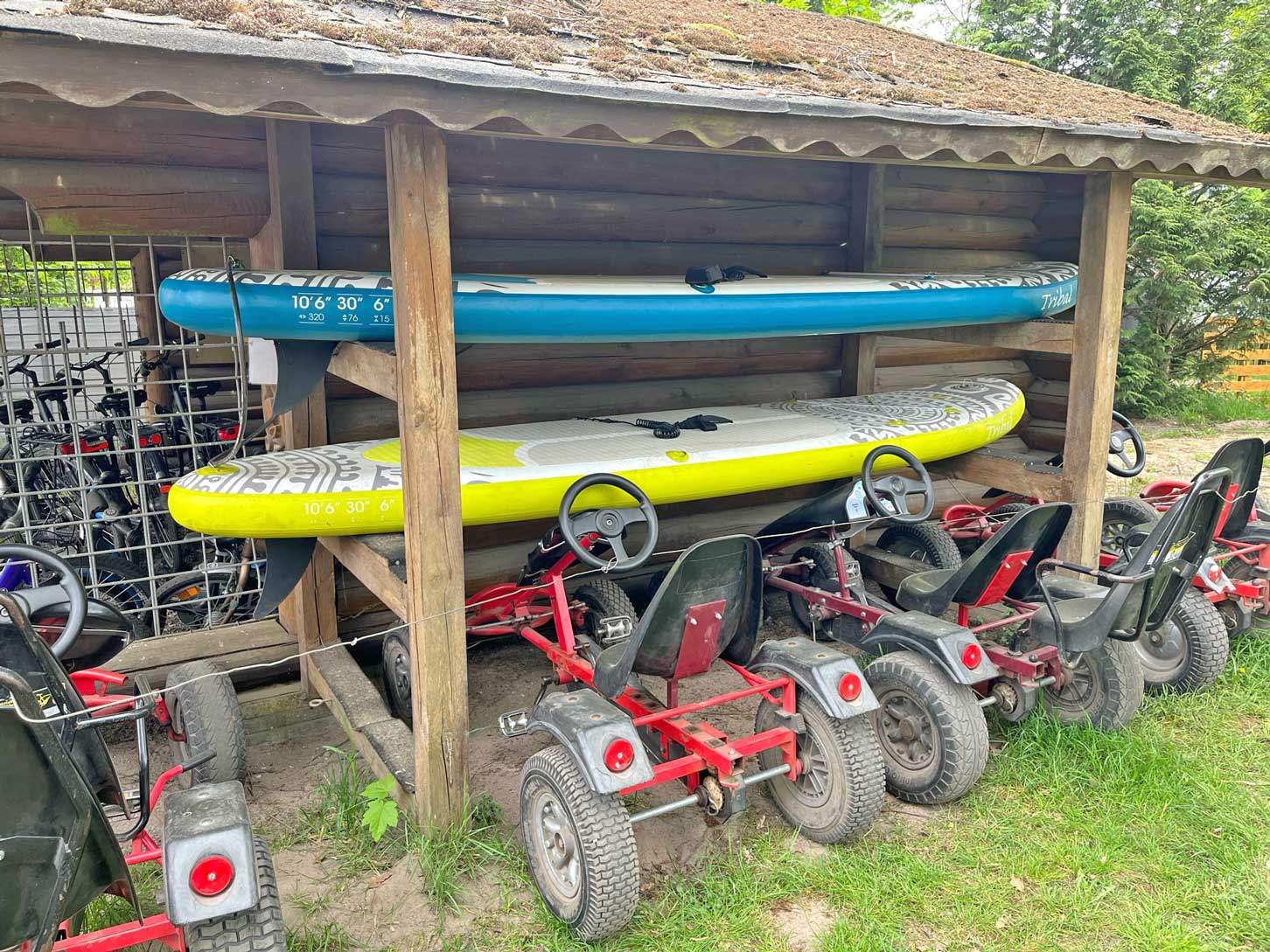 Foto von einem Holzgestellt, auf dem zwei SUP-Boards liegen.