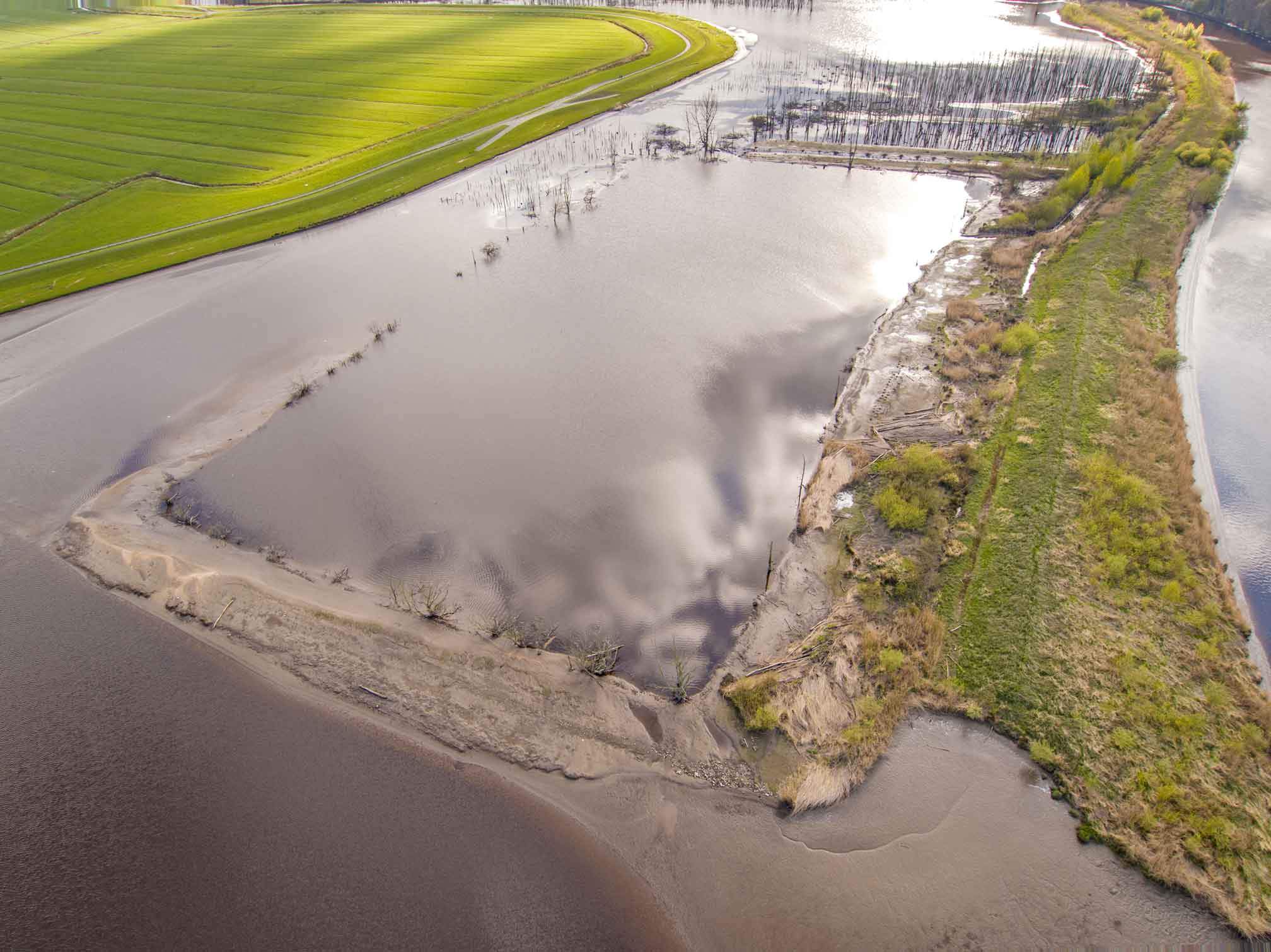 Luftaufnahme von der Pütte Kranenburg mit Deich und Feldern.