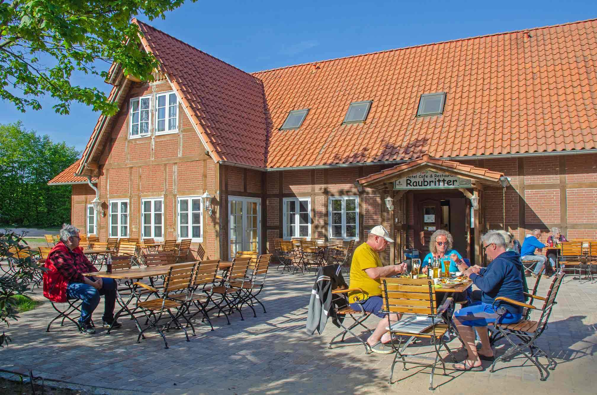 Foto von der Restaurant-Terrasse, auf der Gäste sitzen und essen.