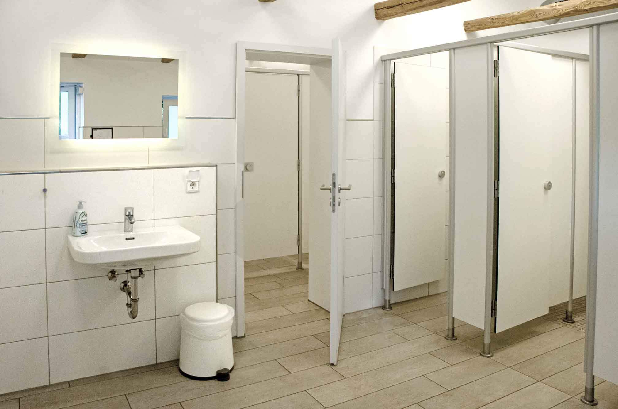 Foto des Duschbereichs im roten Sanitärgebäude mit Duschen, Toiletten und Waschbecken.