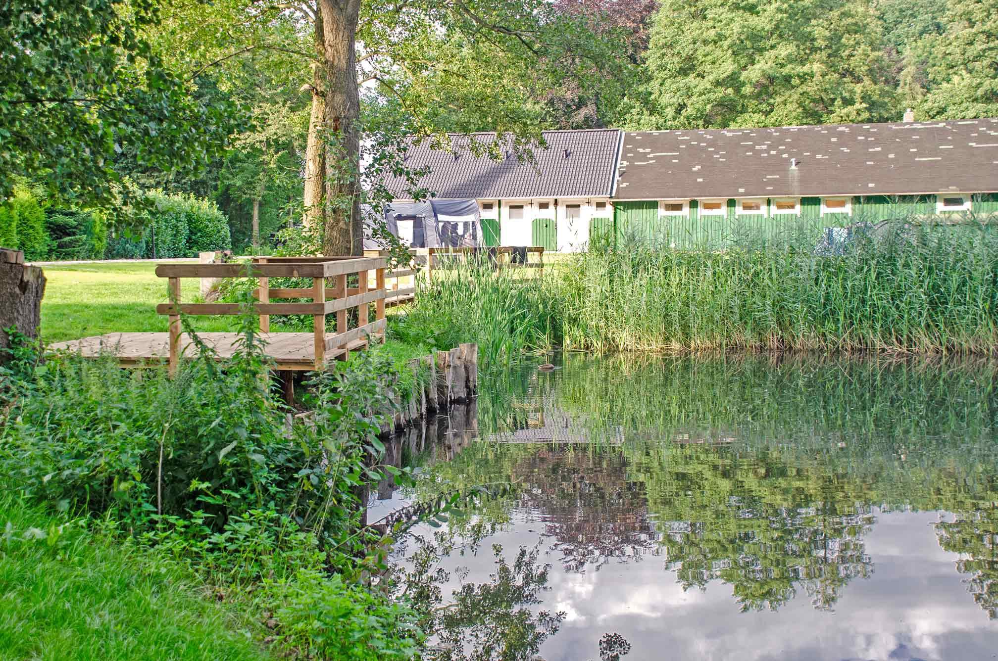 Foto einer Holzterrasse an einem kleinen Ententeich.