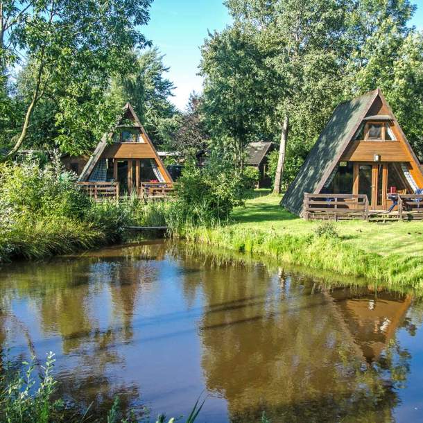 Zwei Holzferienhäuser mit Nurdach am Teich