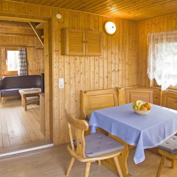 Foto von einem Esszimmger mit kleiner Bank, Stühlen und kleinem Tisch.