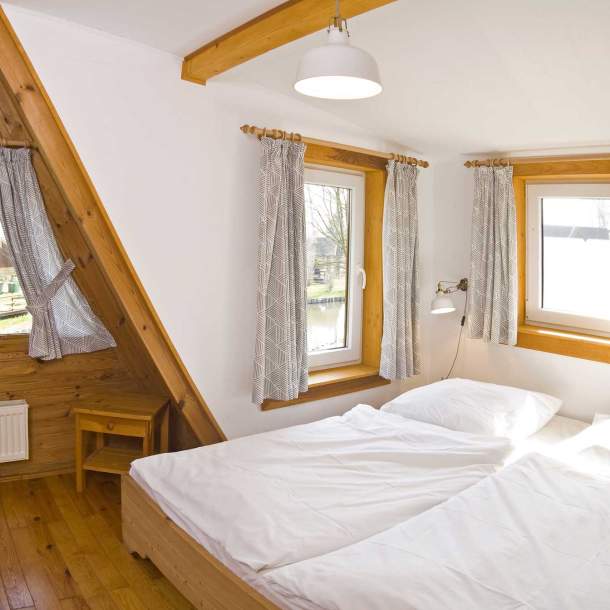 Foto von einem Doppelbett mit bezogener Bettwäsche.