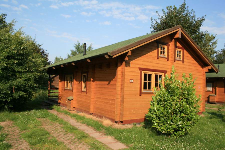 Foto von dem Blockhaus 328 mit kleinem Parkplatz am Haus.