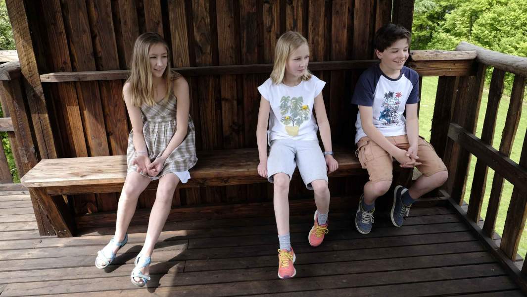 Kinder auf einer Holzbank eines Aussichtsturms