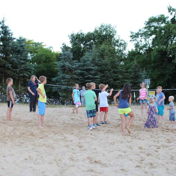 Foto einer Gruppe von Kindern, die ein Ballspiel am Strand spielen.