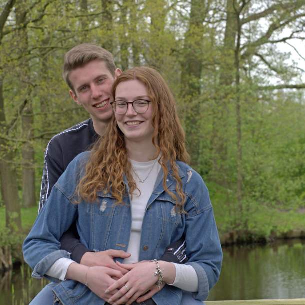 Foto von einem Pärchen, das gemeinsam an einem kleinen Ententeich steht.