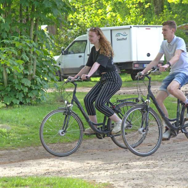 Foto eines Paares auf Fahrrädern in einer Parkanlage.