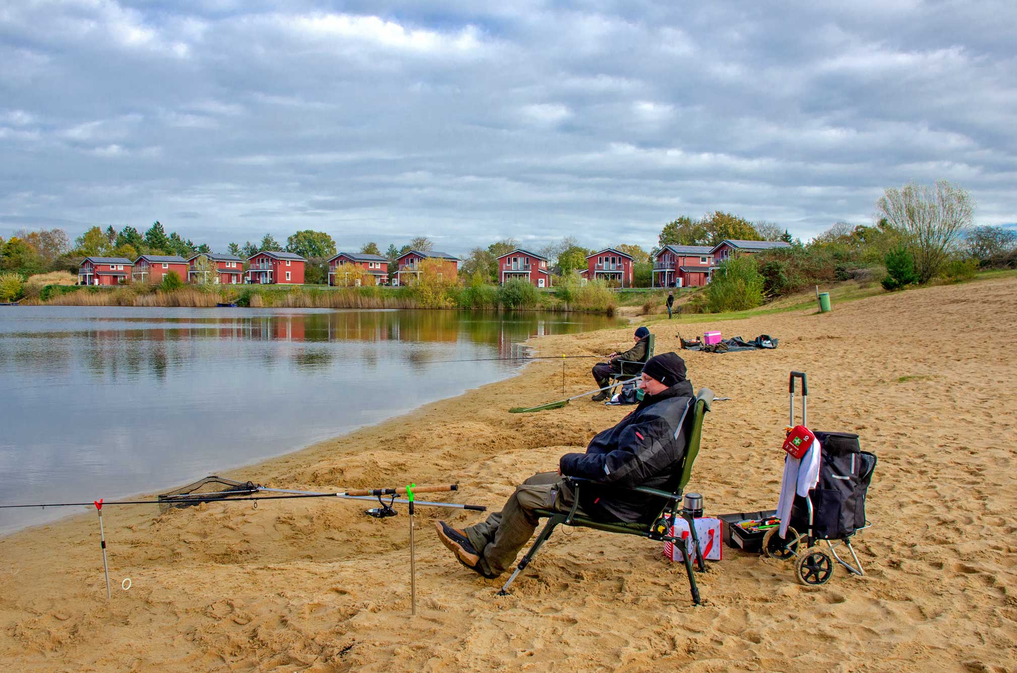 Foto von Anglern am Strand, die ihre Angelrute im Geestsee ausgeworfen haben.