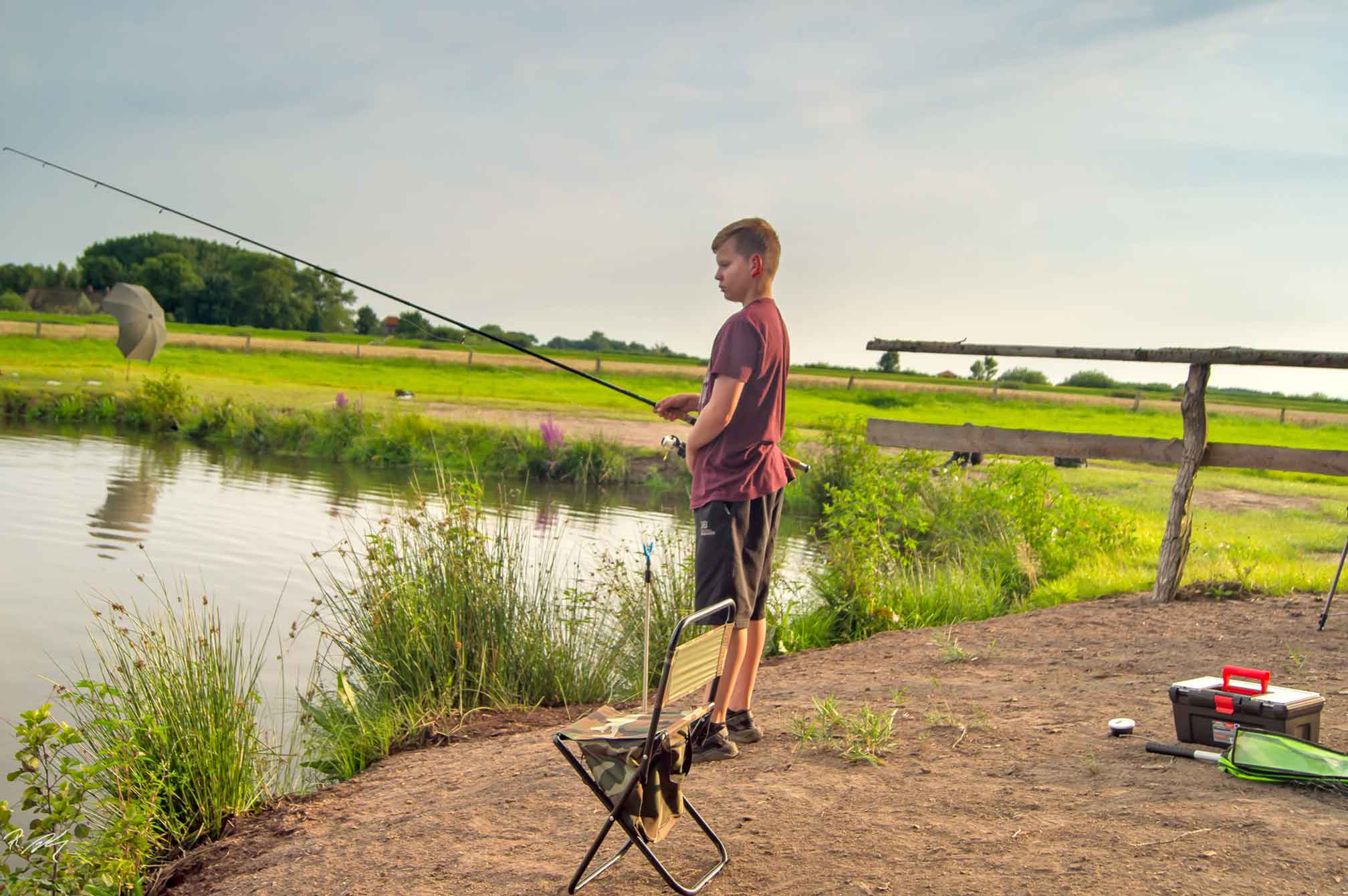 Foto eines jungen Anglers, der am Forellenteich angelt.