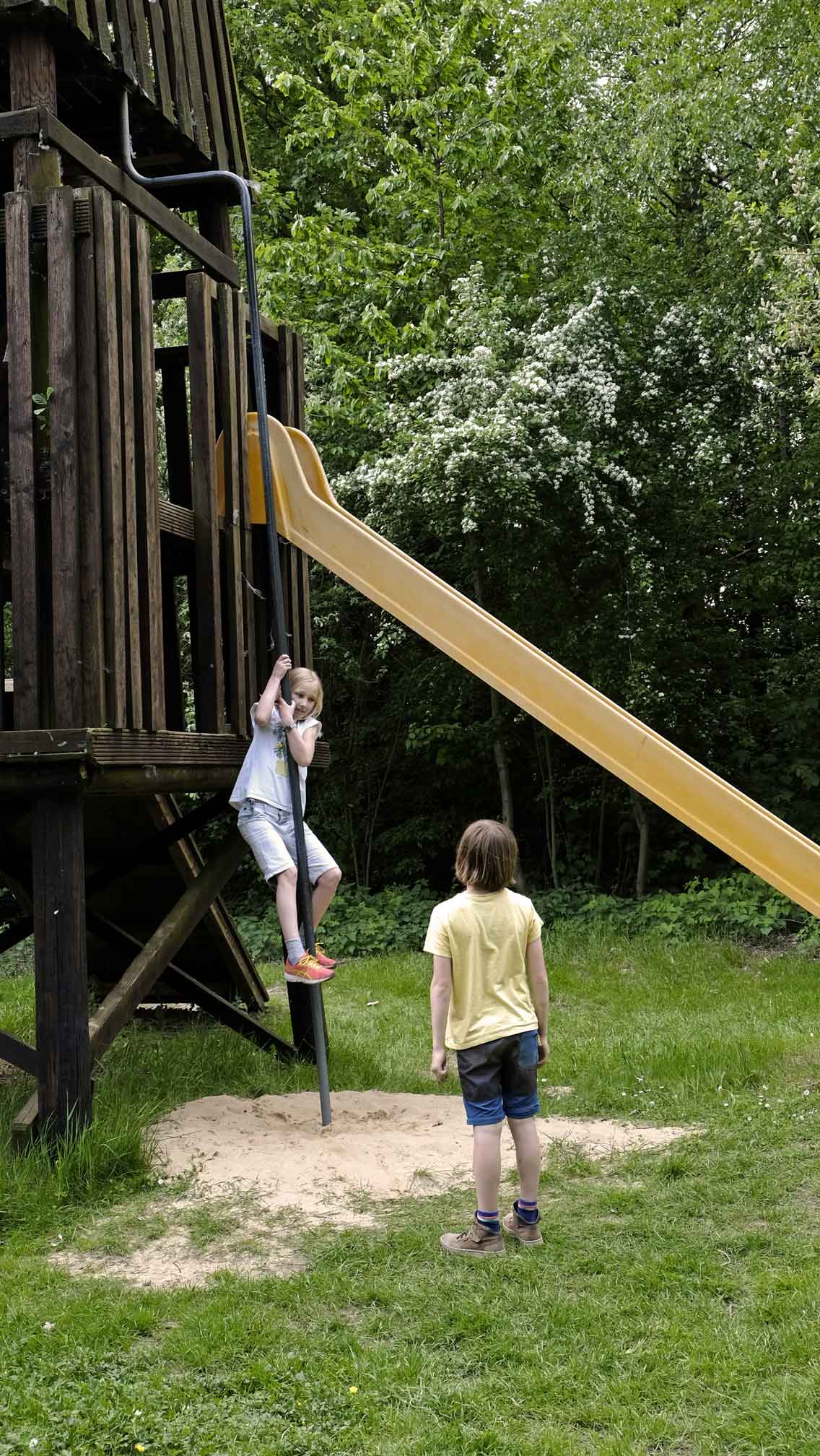 Foto von zwei Kindern auf einem Spielplatz mit Klettergerüst.