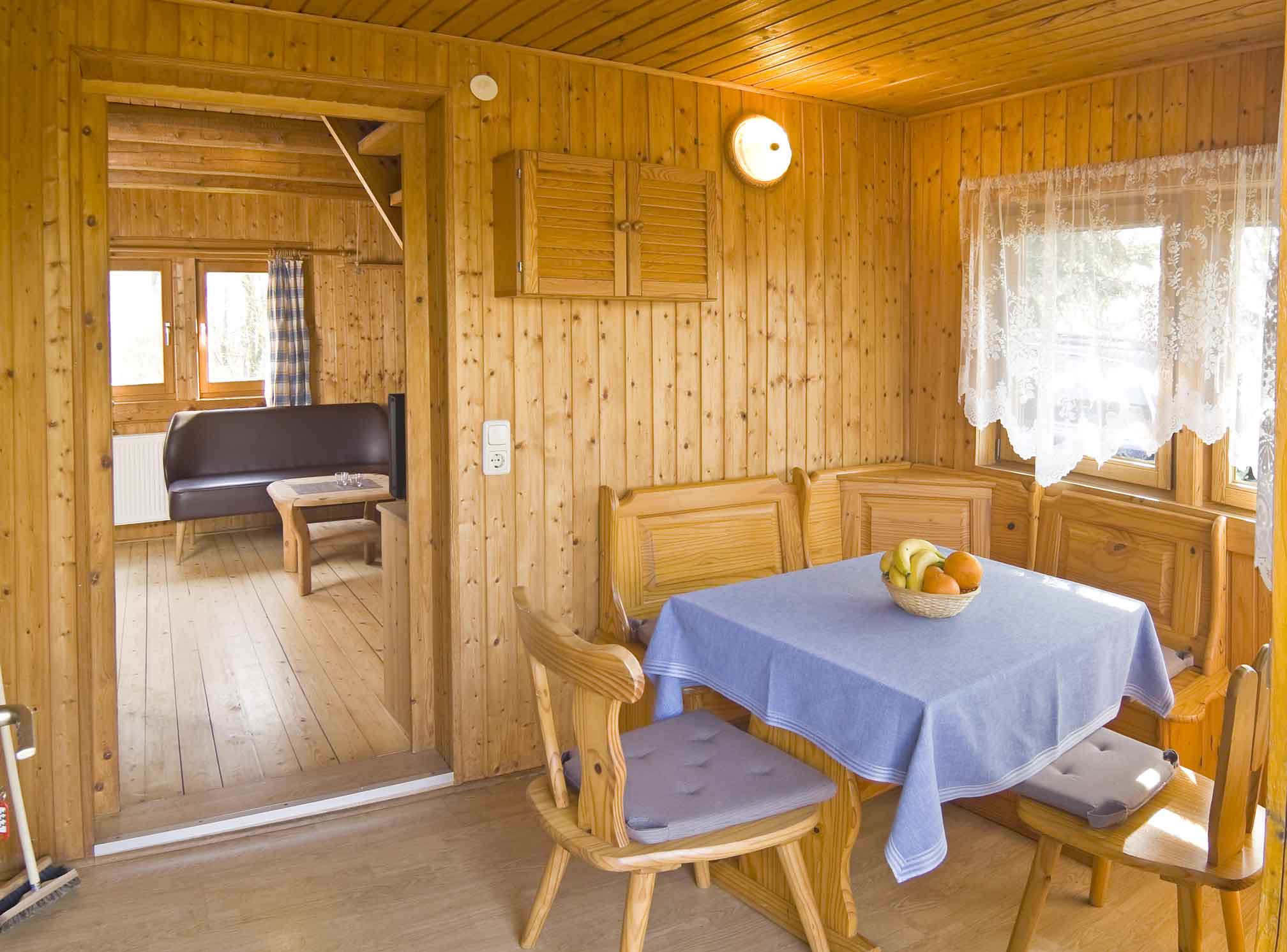 Foto von einem Esszimmger mit kleiner Bank, Stühlen und kleinem Tisch.