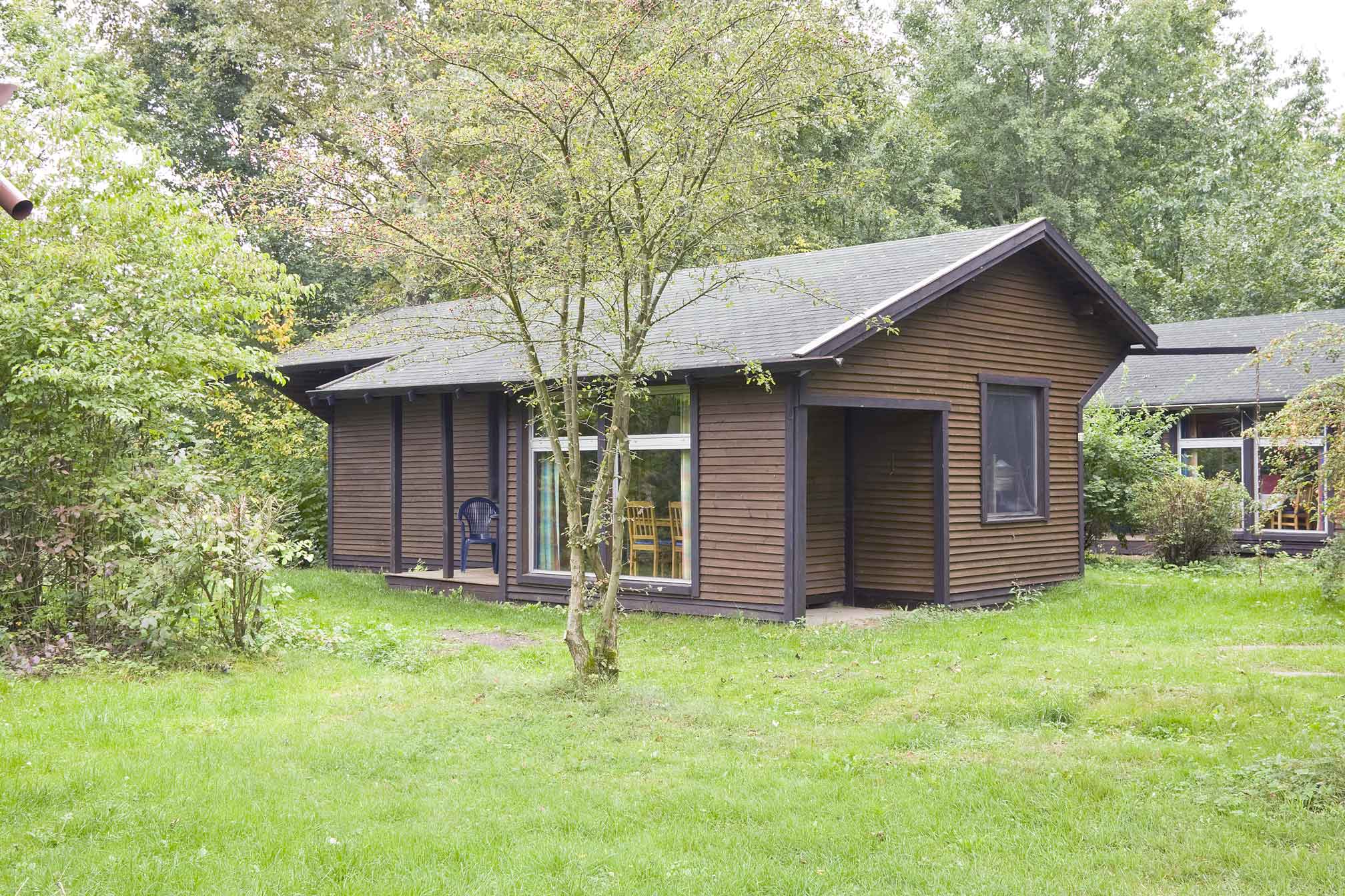 Typ B – Ferienhaus 375 mit flacher Dachform und Holzverkleidung im Grünen