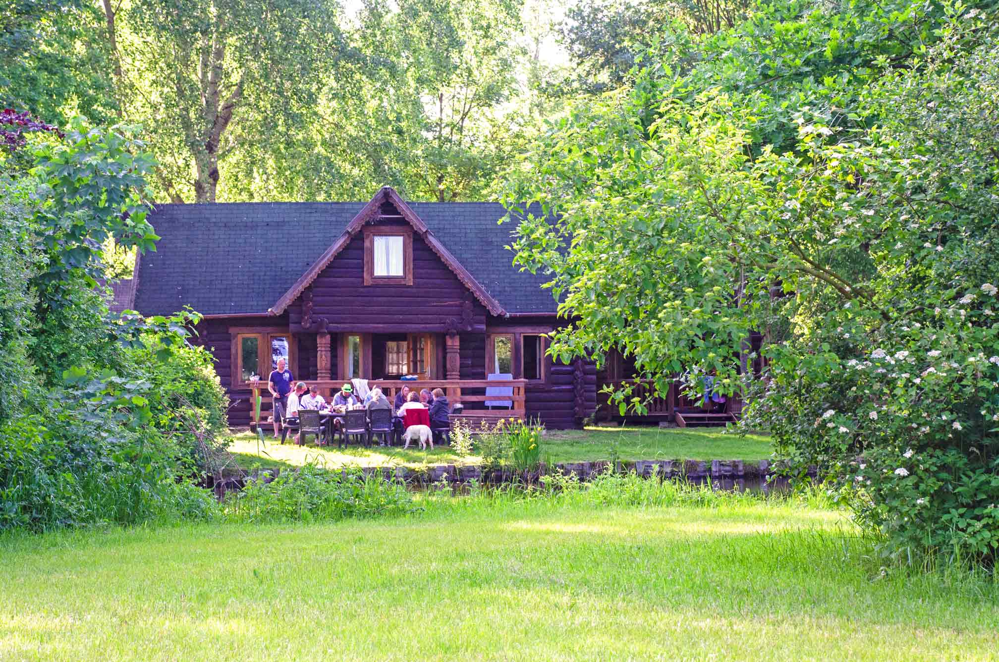 Typ E – karelisches Blockhaus 344 mit Naturdach und massiven Holzstämmen, umgeben von Wiese