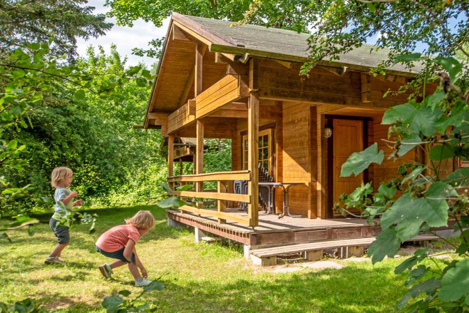 Familienurlaub im Ferienhaus in Niedersachsen – Kinder spielen im Garten in naturnaher Umgebung