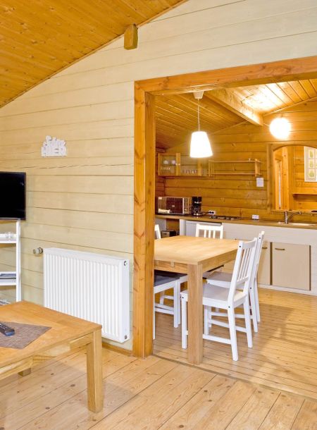 Foto von dem Essbereich im Ferienhaus 362 mit Küche im Hintergrund.