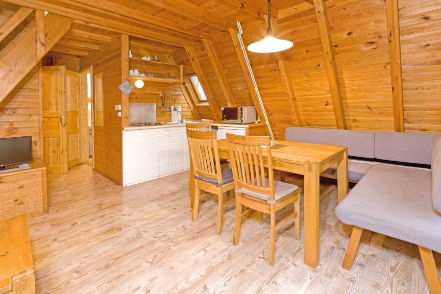Das Bild zeigt das Esszimmer mit offener Küchenzeile im Nurdachhaus 305.