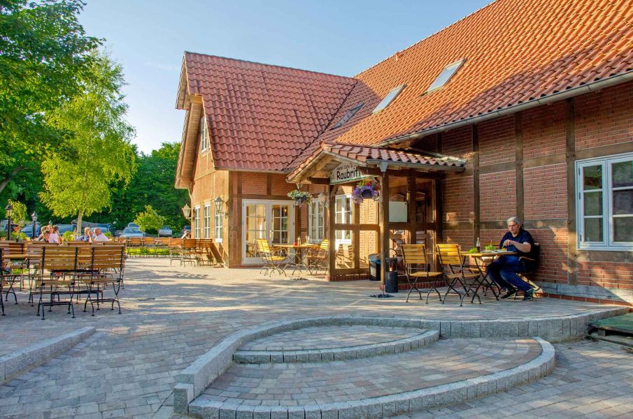 Foto der Restaurant-Terrasse mit Treppe und barrierefreiem Aufgang zum Eingang.