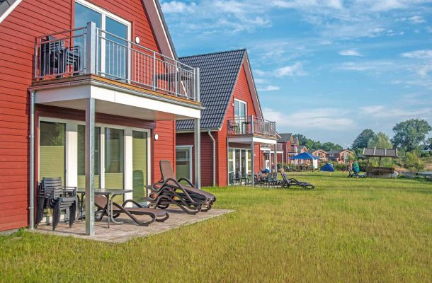 Typ G – Seewohnung 411 mit möblierter Terrasse und Blick auf grüne Wiese