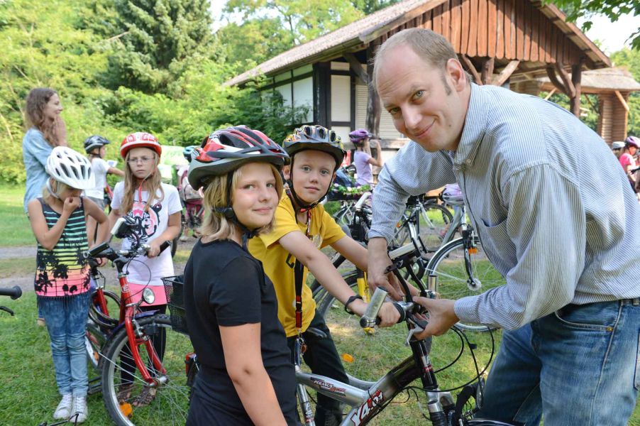 Foto von Kindern, die mit ihren Fahrrädern bereitstehen.