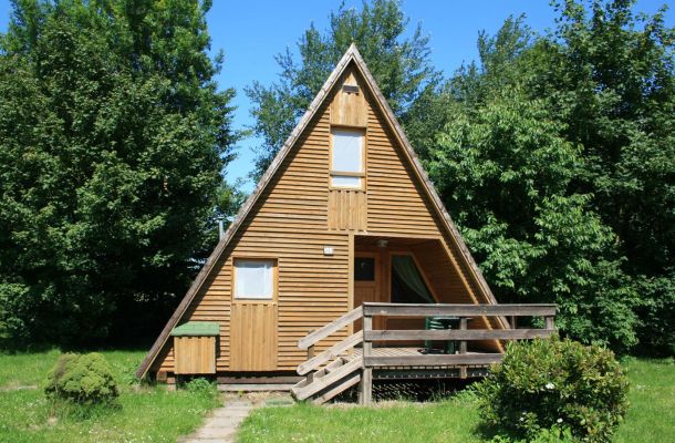 Typ C – Nurdachhaus 313 in spitzem A-Stil mit heller Holzverkleidung und breiter Holzveranda