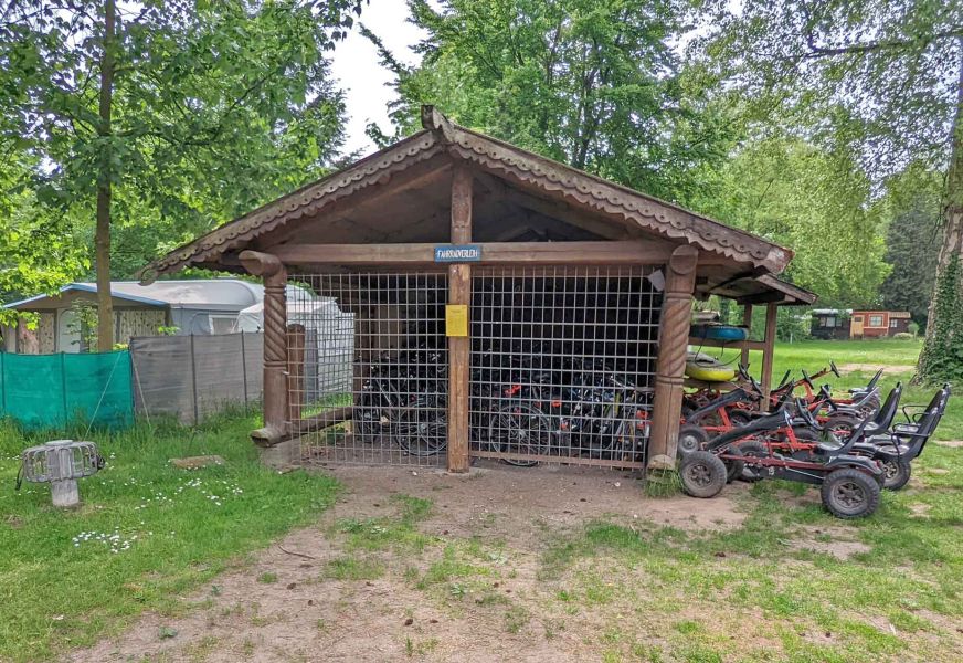 Foto eines Fahrradschuppens mit mehreren Fahrrädern und Kettcars.