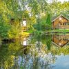 Foto von mehreren Holzferienhäuser, die an einem Teich stehen.