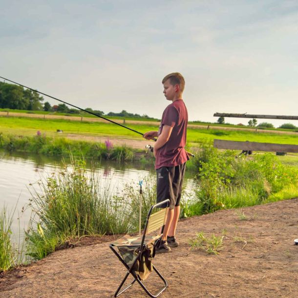 Foto eines jungen Anglers, der am Forellenteich angelt.
