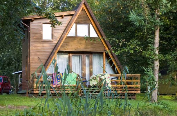 Typ D – Nurdachhaus 339 mit brauner Holzfassade, grünem Dach und Frontfenster im A-Frame-Stil