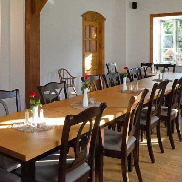 Foto des Clubraums im Restaurant "Raubritter" mit einer langen Tafel und dekorierten Tischen.