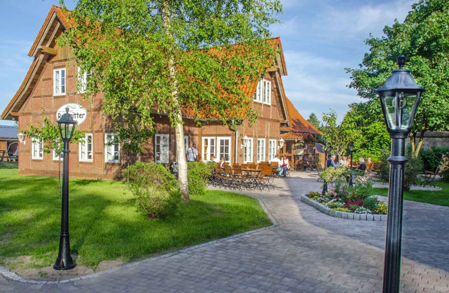 Foto eines gepflasterten Weges, der zum Restaurant "Raubritter" über die große Terrasse führt.
